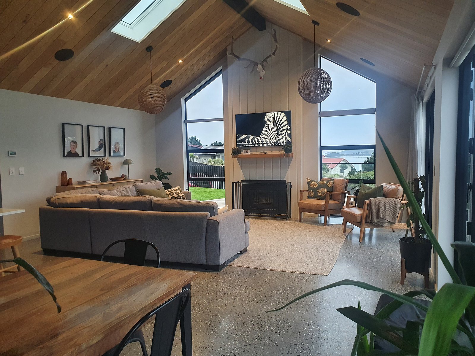 Vaulted living room with timber ceiling, skylights and a log burner
