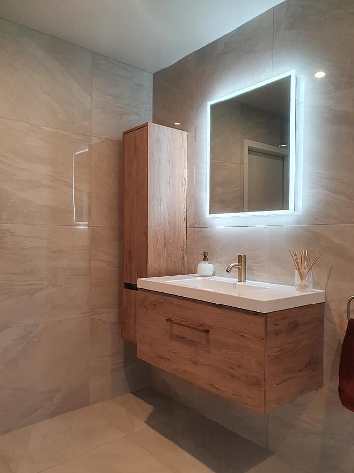 Renovated bathroom with a floating timber vanity and backlit mirror