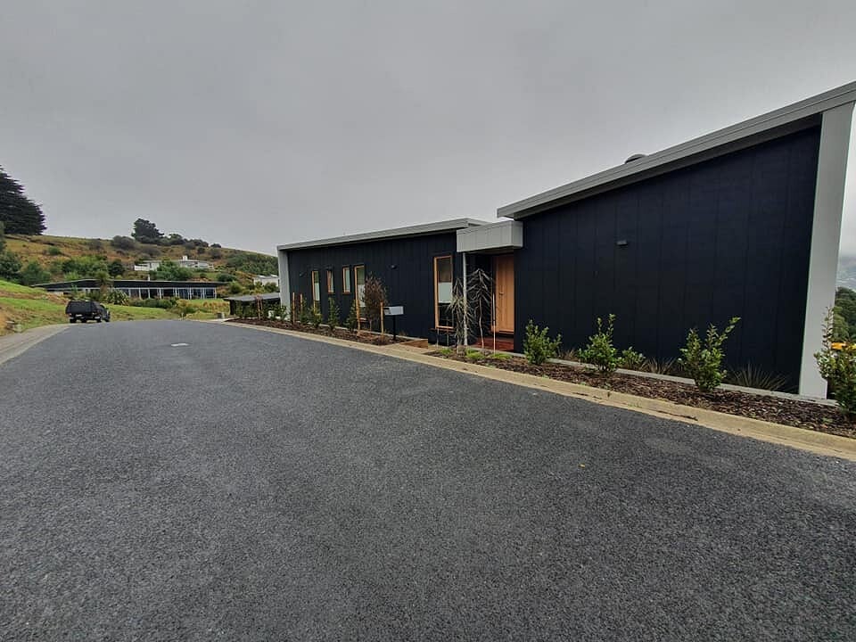 Two dark clad units with a new sealed driveway