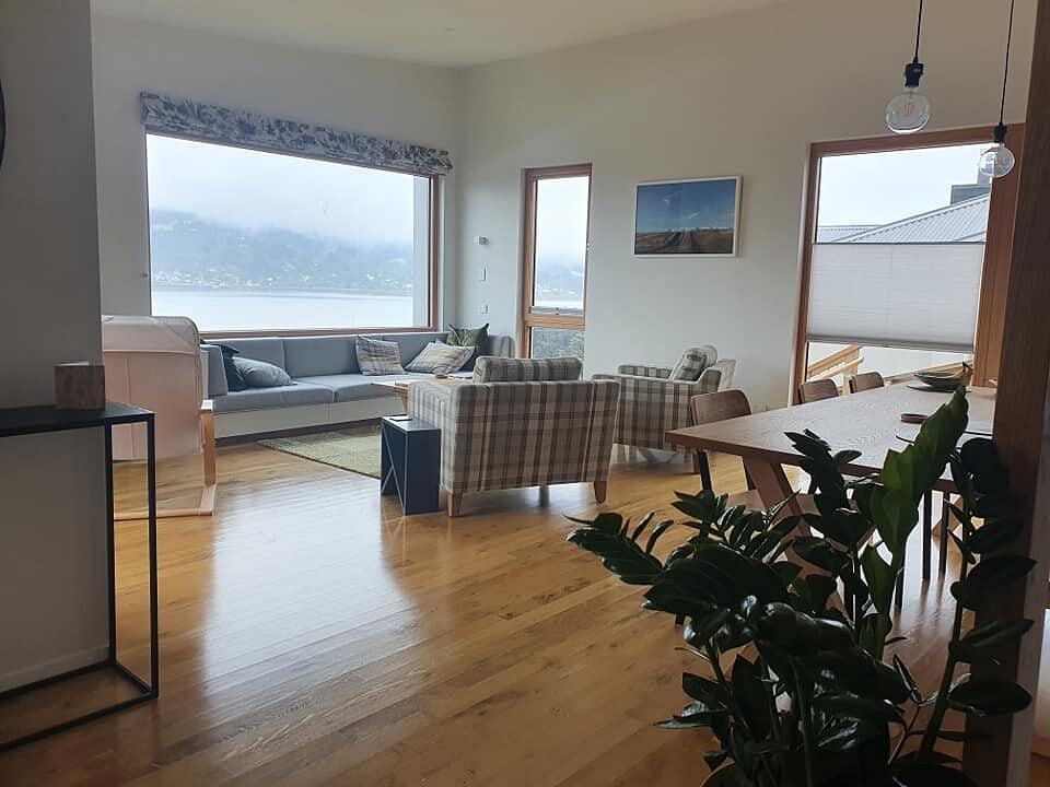 Open-plan lounge with harbour views through full-height windows