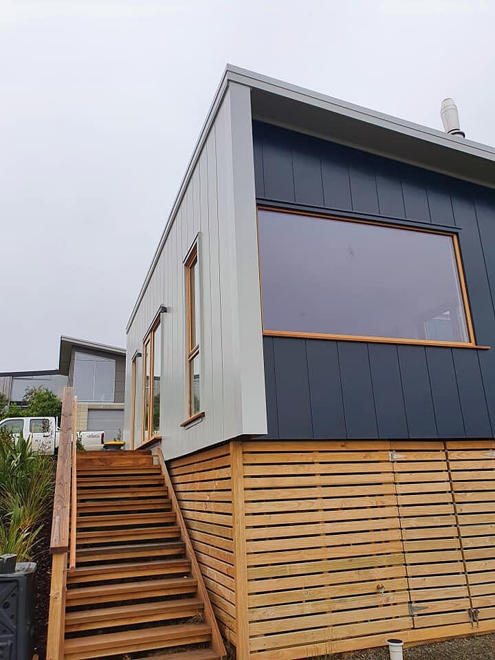 Two-tone cedar and dark cladding on a new Dunedin home with timber stairs